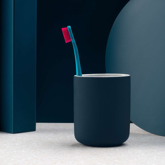 Curaprox CS 5460 ultra soft toothbrush with dense red bristles in a dark blue holder against minimalistic background