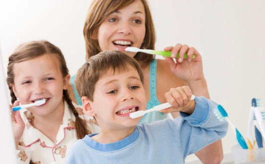 Mother and children brushing teeth together, promoting fun winter brushing routines for kids