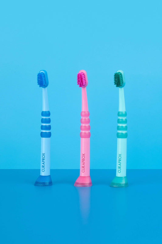 Curaprox Baby Toothbrushes for 0-4 years with fine, dense Curen filaments and rubberized heads in blue, pink, and green colors.