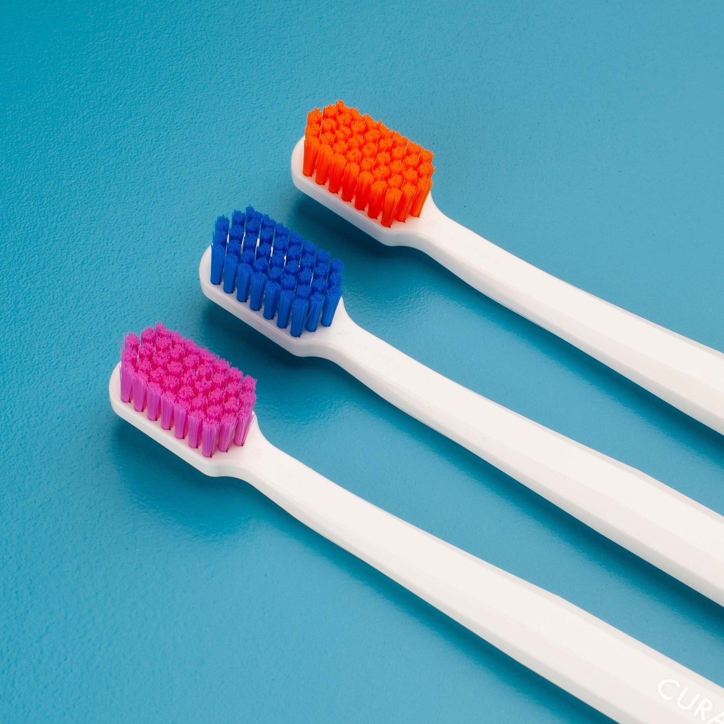 Curaprox CS 5460 ultra soft toothbrushes with dense colorful bristles on white handles for gentle and effective dental care